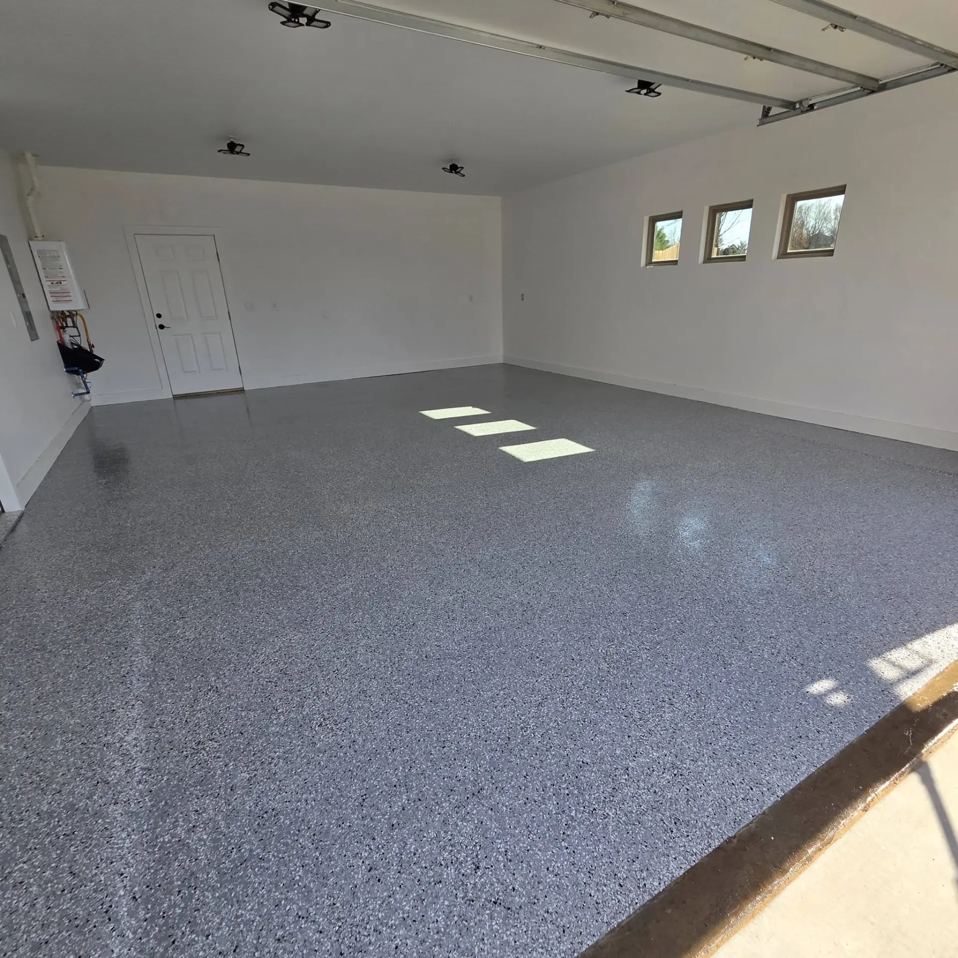The same garage finished with a gray and blue broadcast flake epoxy floor